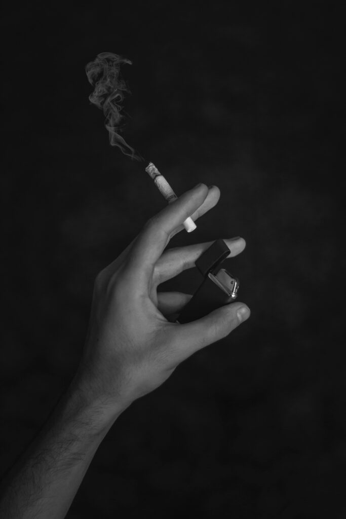 Hand holding a cigarette and a lighter