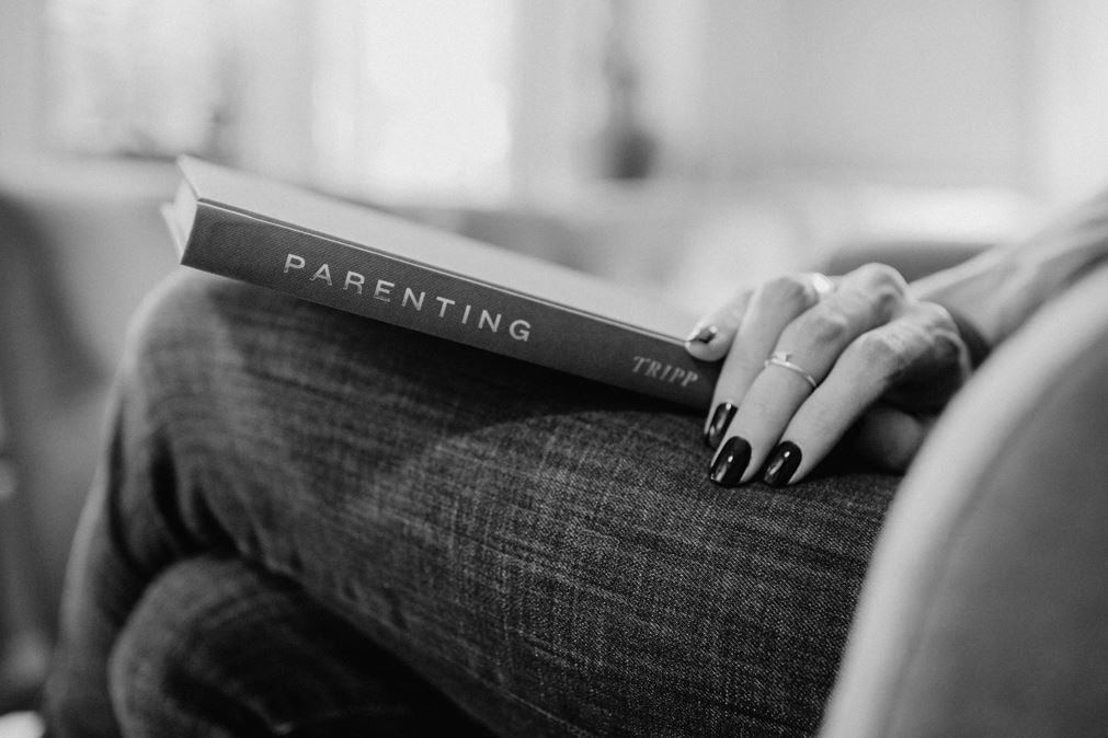 A woman holding a parenting book