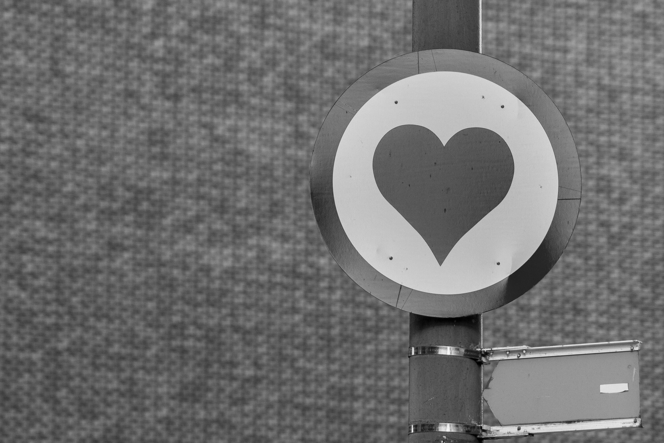 A road sign of a heart on a post