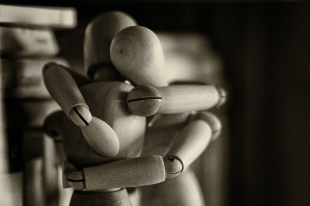 Two wooden dummy dolls hugging